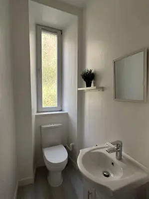a white bathroom with a toilet and a sink at Combie Lane Apartments in Oban