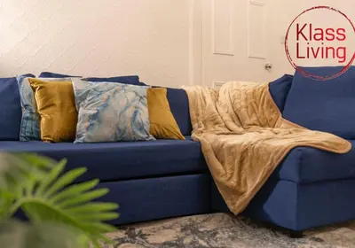 a blue couch with a blanket on it at Bute Apartment by Klass Living Coatbridge in Coatbridge