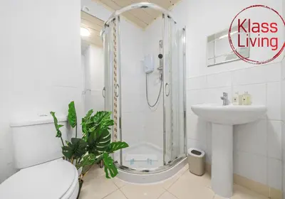 a bathroom with a shower and a toilet and a sink at Bute Apartment by Klass Living Coatbridge in Coatbridge