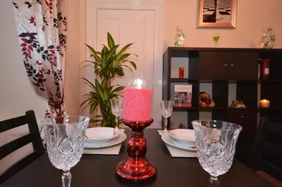 a table with a red candle and glasses on it at Wallace Apartment in Stirling