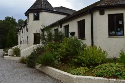 a house with some flowers in front of it at MacDonald Hotel & Cabins in Kinlochleven