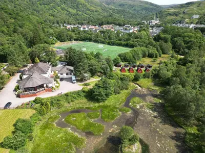an aerial view of a house in the mountains at MacDonald Hotel & Cabins in Kinlochleven
