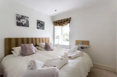 a bedroom with a large white bed with towels on it at Argyll Barn in Colintraive