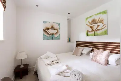 a bedroom with a large white bed and two pictures on the wall at Argyll Barn in Colintraive