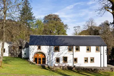 a white barn with a black roof at Argyll Barn in Colintraive