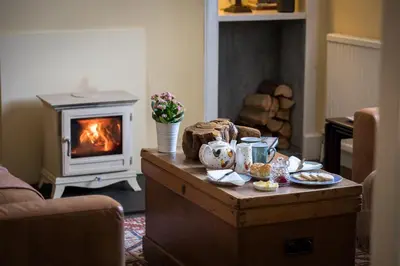 a living room with a coffee table with a fireplace at Kilmaronock Manse B&B in Drymen
