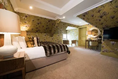 a bedroom with a bed and a desk in a room at Gleddoch Golf & Spa Resort in Langbank