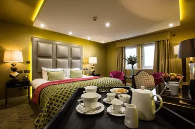 a hotel room with a bed and a table with dishes on it at Gleddoch Golf & Spa Resort in Langbank