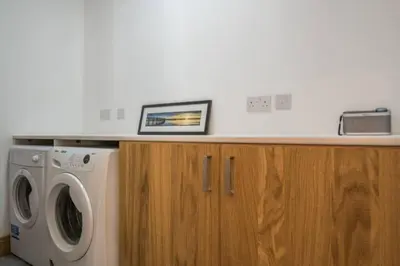 a laundry room with a washing machine and a counter at Luxury Flat, 20 Minutes by train from Edinburgh in Inverkeithing