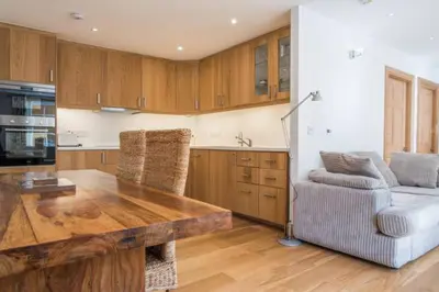 a kitchen with a wooden table and a couch at Luxury Flat, 20 Minutes by train from Edinburgh in Inverkeithing