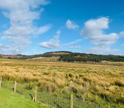 a field with a fence in the middle of a field at The Pod Over By in Kilmichael Glassary