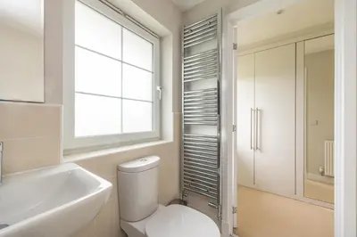 a bathroom with a toilet and a sink and a window at Luxury Detached Home in Edinburgh