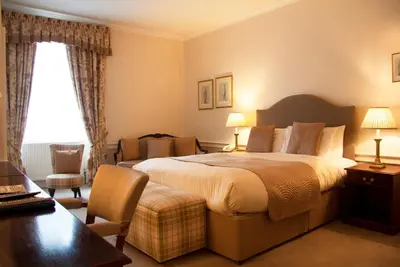 a hotel room with a large bed and a desk at Royal Scots Club in Edinburgh