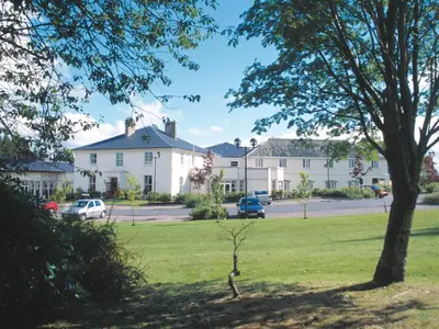 a view of a yard with houses and a tree at Macdonald Crutherland House in East Kilbride
