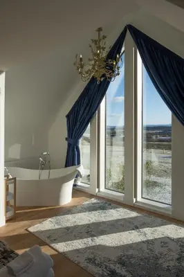a bathroom with a tub and a large window at Robin Cottage in Buchanty