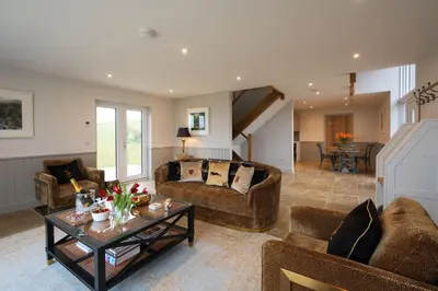 a living room with two couches and a table at Robin Cottage in Buchanty
