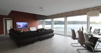 a large living room with a large couch and chairs at Ferrypoint House in Rhu