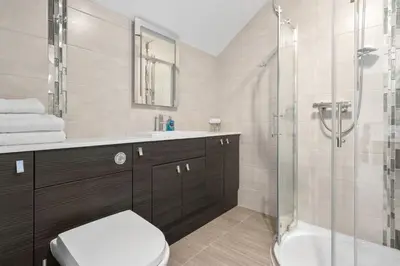 a bathroom with a shower and a toilet and a sink at Ferrypoint House in Rhu