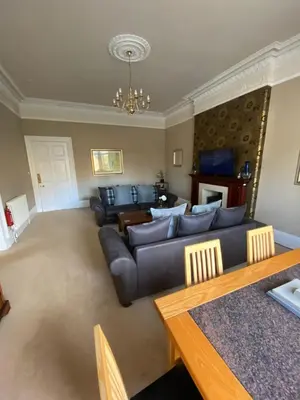 a living room with a couch and a table at Beautiful & bright 2 bed flat Murrayfield in Edinburgh