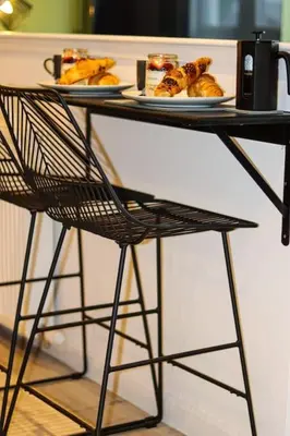 a table with two plates of food and a chair at City Hub by the Castle Free Designated Parking in Stirling