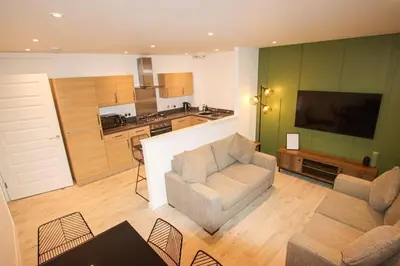 a living room with two couches and a kitchen at City Hub by the Castle Free Designated Parking in Stirling