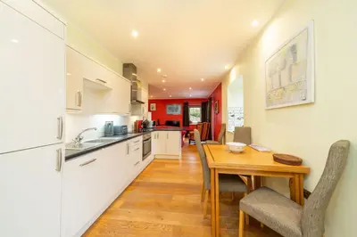 a kitchen and dining room with a wooden table at Lochelour Mill Cottage in Perth