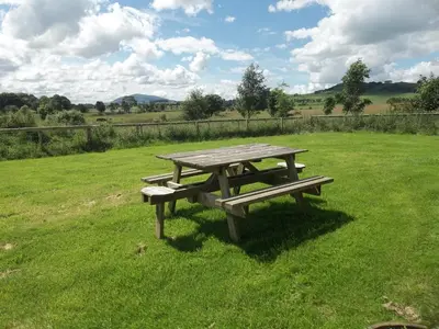 a picnic table in the middle of a field at The New Farmhouse in Biggar