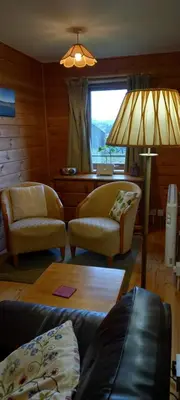 a living room with a couch and chairs and a lamp at The New Farmhouse in Biggar