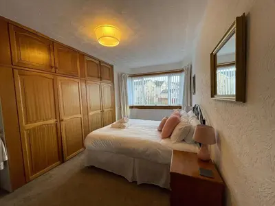 a bedroom with a large bed and a window at 1930s 3Bed House in Quiet Village w/ Large Garden in Bishopton