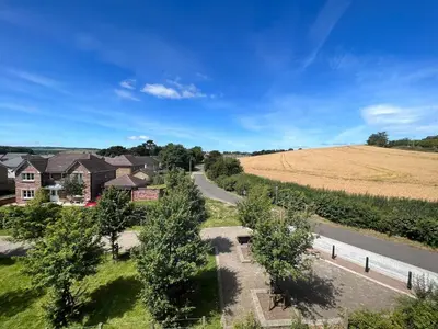 an aerial view of a house with a road and a field at Modern 2 Bedroom Flat in Quiet Village w/ Ensuite in Bishopton