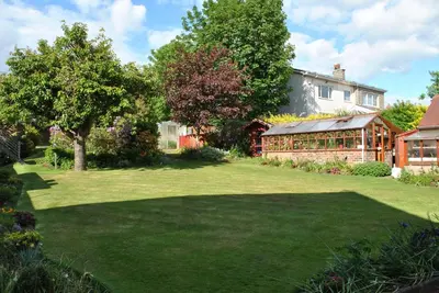 a garden with a house and a large yard at Willowbank Hotel in Largs