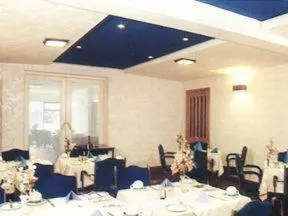 a dining room with tables and chairs with white table cloth at Willowbank Hotel in Largs