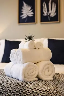 a stack of towels sitting on top of a bed at City Views by the Castle, Free Designated Parking. in Stirling