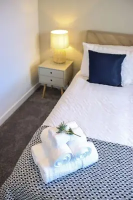 a bedroom with a bed with towels on it at City Views by the Castle, Free Designated Parking. in Stirling