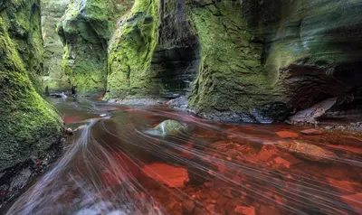 a long exposure photo of a stream in a canyon at The Mar Huts - The Conic Hut in Drymen