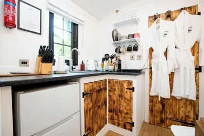 a kitchen with wooden cabinets and a counter top at The Mar Huts - The Conic Hut in Drymen
