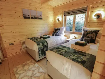 a bedroom with two beds in a log cabin at Little Lodge in Newton Stewart