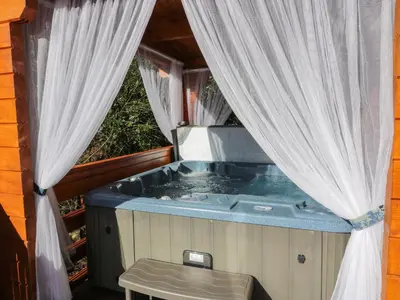 a jacuzzi tub in a house with curtains at Little Lodge in Newton Stewart