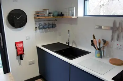 a kitchen with a sink and a clock on the wall at Tigh Na Beithe in North Ballachulish