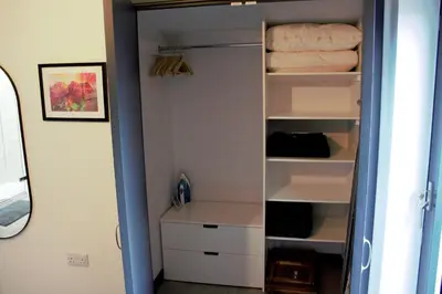 a closet with white shelves and a bed at Tigh Na Beithe in North Ballachulish