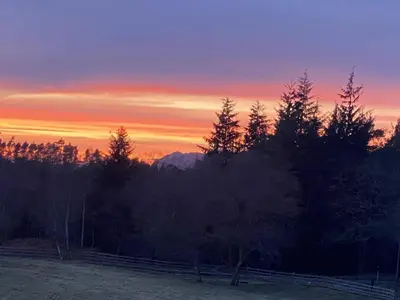 a sunset over a field with trees and a mountain at The Annex at Meeks Park immaculate 2 bed in Alloa