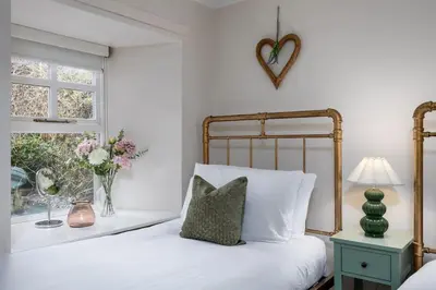 a bedroom with a bed and a vase of flowers at The Tranquil Auchterarder 3-bed Cottage in Auchterarder