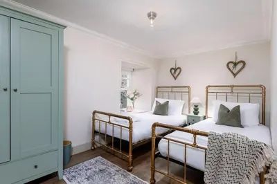 two beds in a bedroom with white walls at The Tranquil Auchterarder 3-bed Cottage in Auchterarder