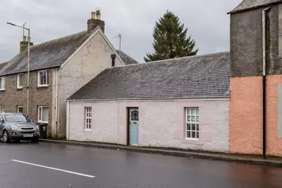 a white building on the side of a street at The Tranquil Auchterarder 3-bed Cottage in Auchterarder