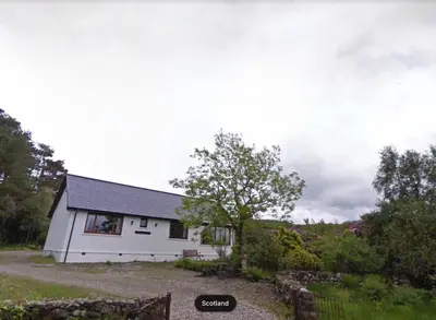 a white house with a tree in front of it at Fuaim Na Mara, The Sound Of The Sea. in Fort William