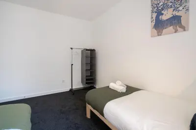 a room with two beds and a book shelf at 2 Bedroom Apartment-Free Parking-by Holiday Homes in Wishaw