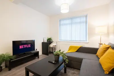 a living room with a couch and a tv at 2 Bedroom Apartment-Free Parking-by Holiday Homes in Wishaw