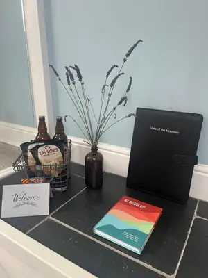 a vase with a book and a laptop on a counter at View of the Mountain in North Ballachulish