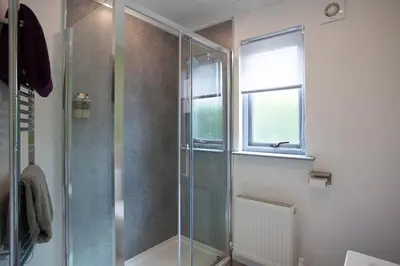 a bathroom with a glass shower with a window at View of the Mountain in North Ballachulish