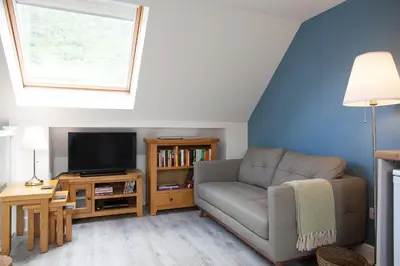 a living room with a couch and a tv at View of the Mountain in North Ballachulish